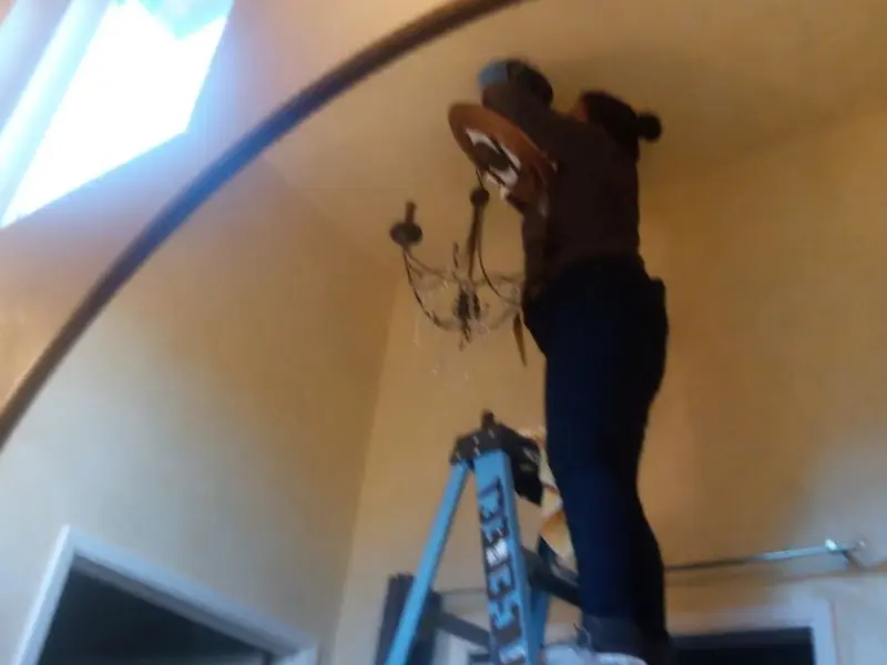 Electrician installing a chandelier in a Norfolk residence